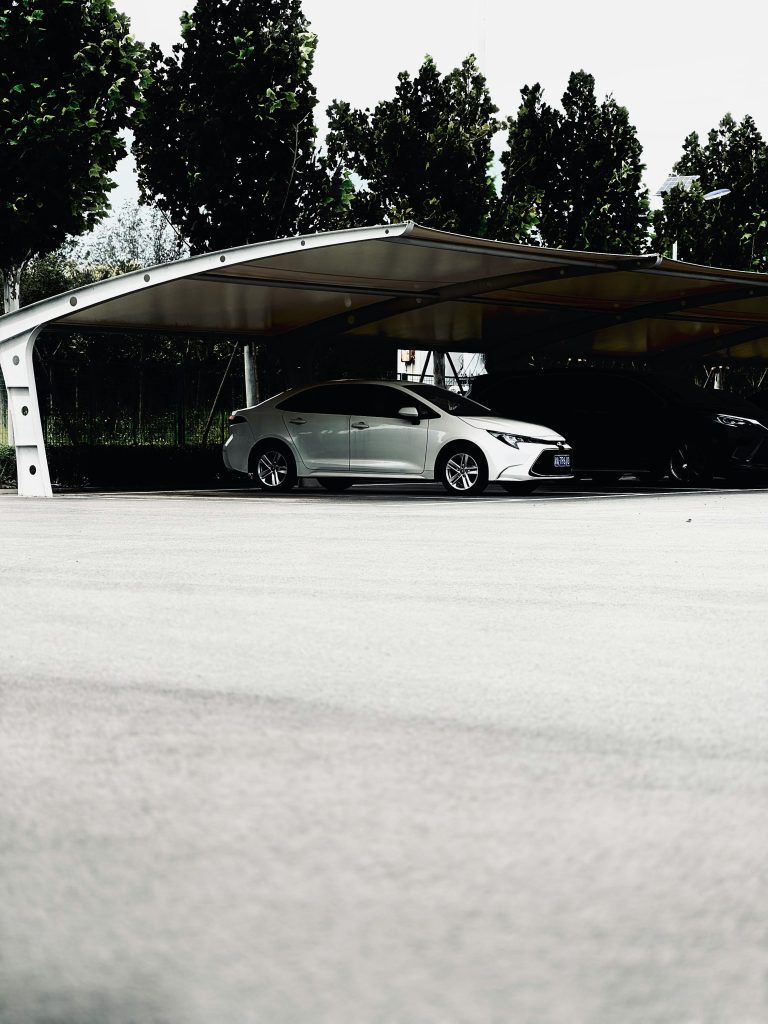 Une voiture moderne garée sous un auvent élégant dans un environnement urbain, offrant un espace de stationnement spacieux.