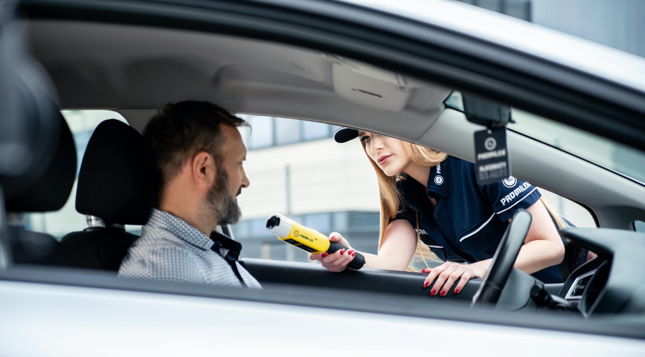 Un policier effectue un test d'alcoolémie sur un conducteur masculin lors d'un contrôle routier de sécurité.