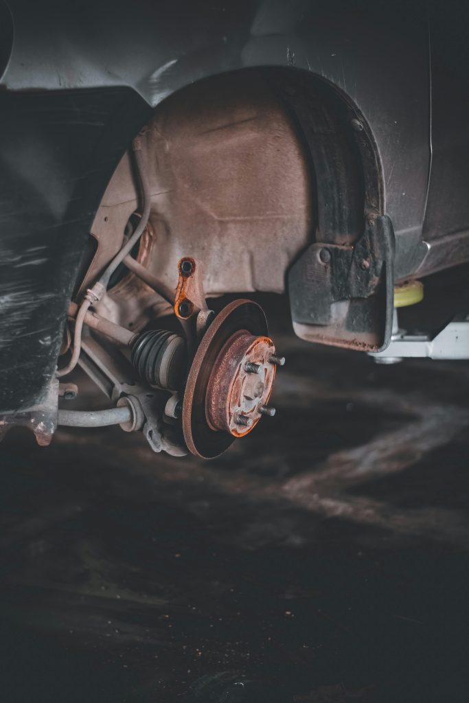 Close-up of a rusty car brake system highlighting repair needs and maintenance. Gros plan d'un système de freinage automobile rouillé mettant en évidence les besoins de réparation et d'entretien.
