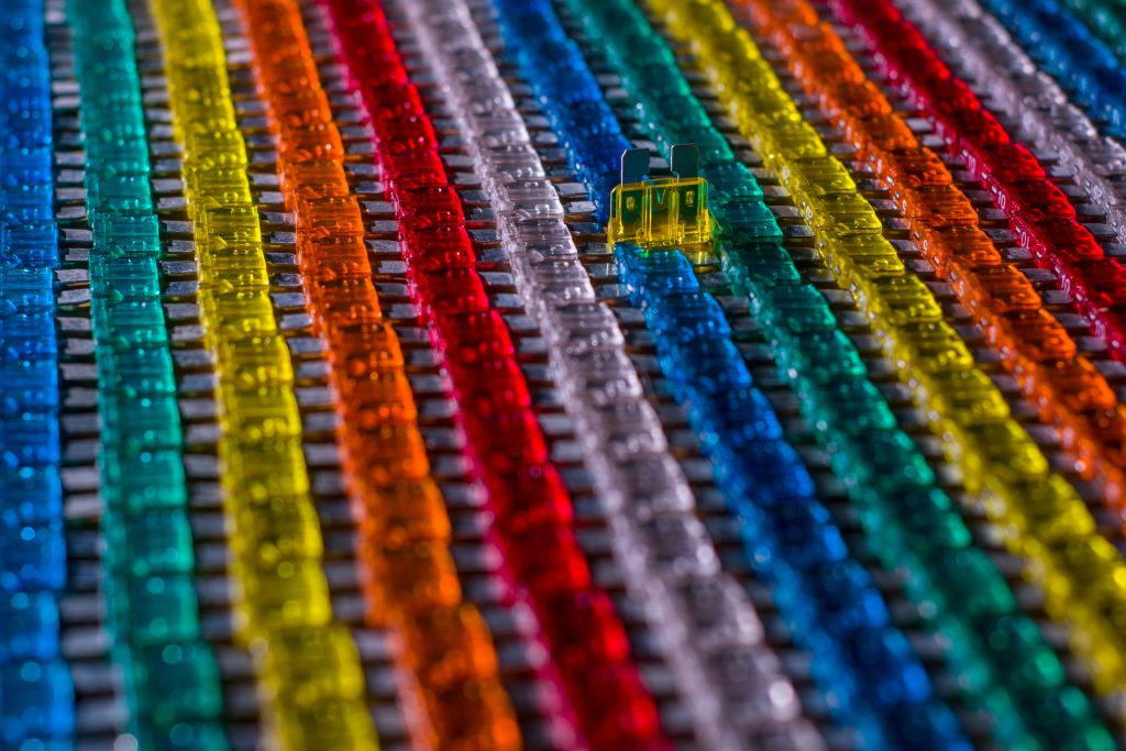 From above of colorful electrical automotive blade type fuses placed in rows in factory Vue de dessus de fusibles automobiles colorés de type lame disposés en rangées en usine