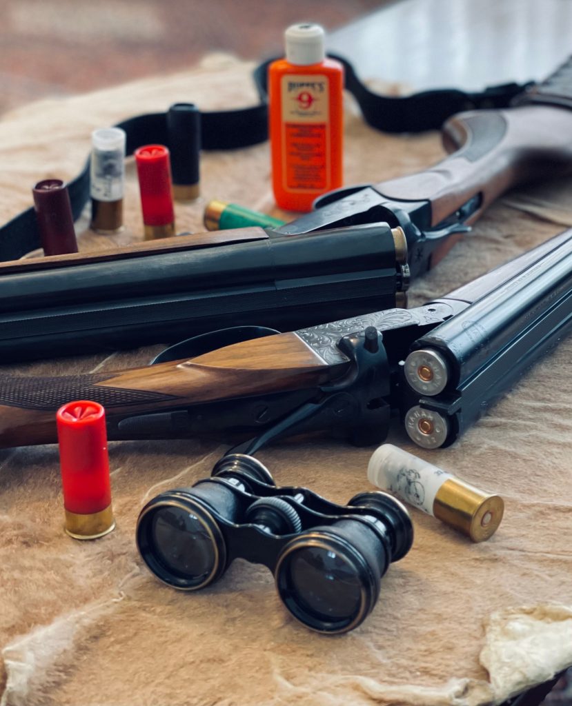Shotgun with ammunition and binoculars on fur. Ideal for hunting themes. Fusil de chasse avec munitions et jumelles sur fourrure. Idéal pour les thèmes de chasse.