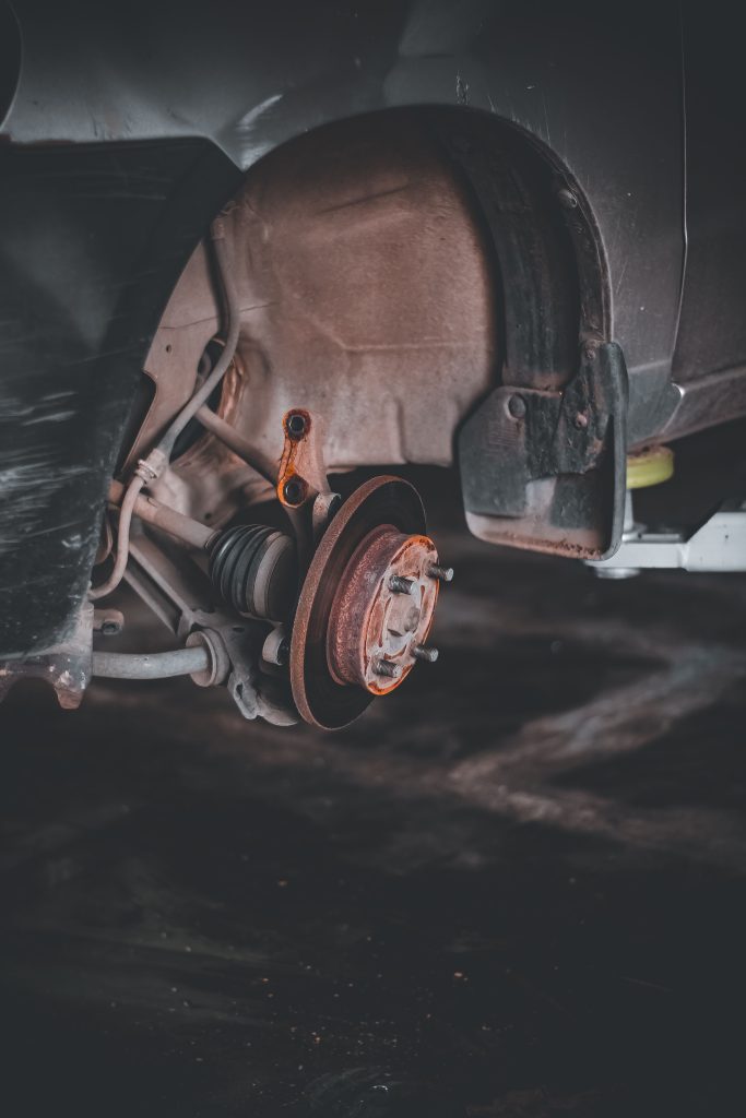 Close-up of a rusty car brake system highlighting repair needs and maintenance. Gros plan d'un système de freinage de voiture rouillé mettant en évidence les besoins de réparation et d'entretien.