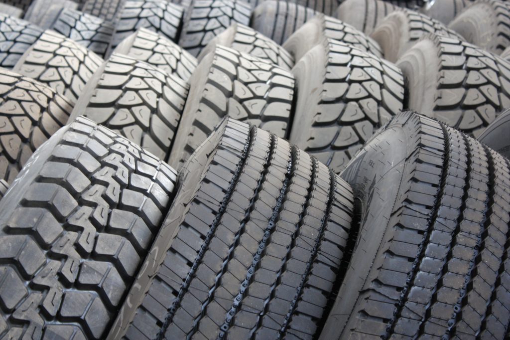 High-quality image of stacked industrial tires showcasing tread patterns. Image de haute qualité de pneus industriels empilés mettant en évidence les motifs de sculpture.
