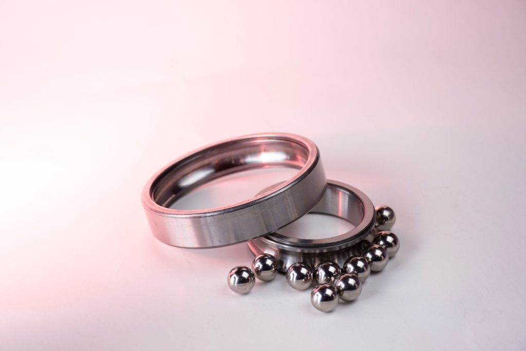 Detailed image of shiny metal bearings and rings on a white background. Image détaillée de roulements métalliques brillants et d'anneaux sur un fond blanc.