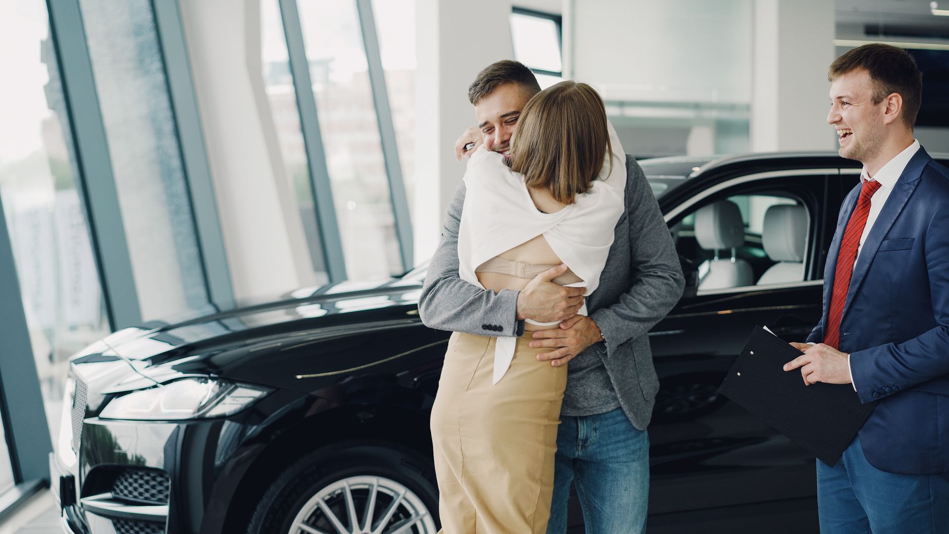Couple récupérant les clés de sa nouvelle voiture