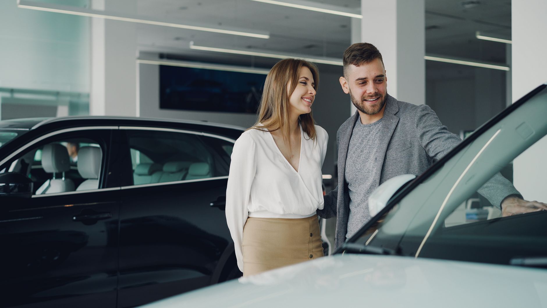 Couple qui examine une voiture d'occasion chez un concessionnaire