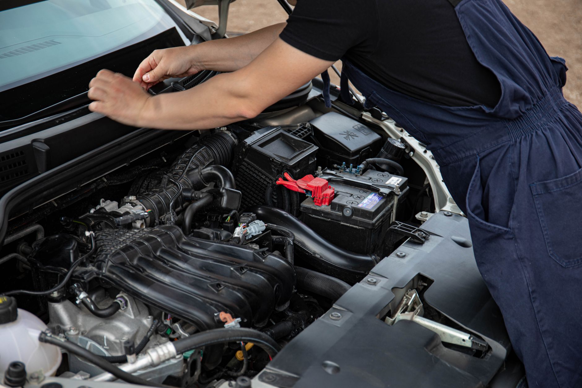 Mécanicien qui contrôle le compartiment moteur d’une voiture