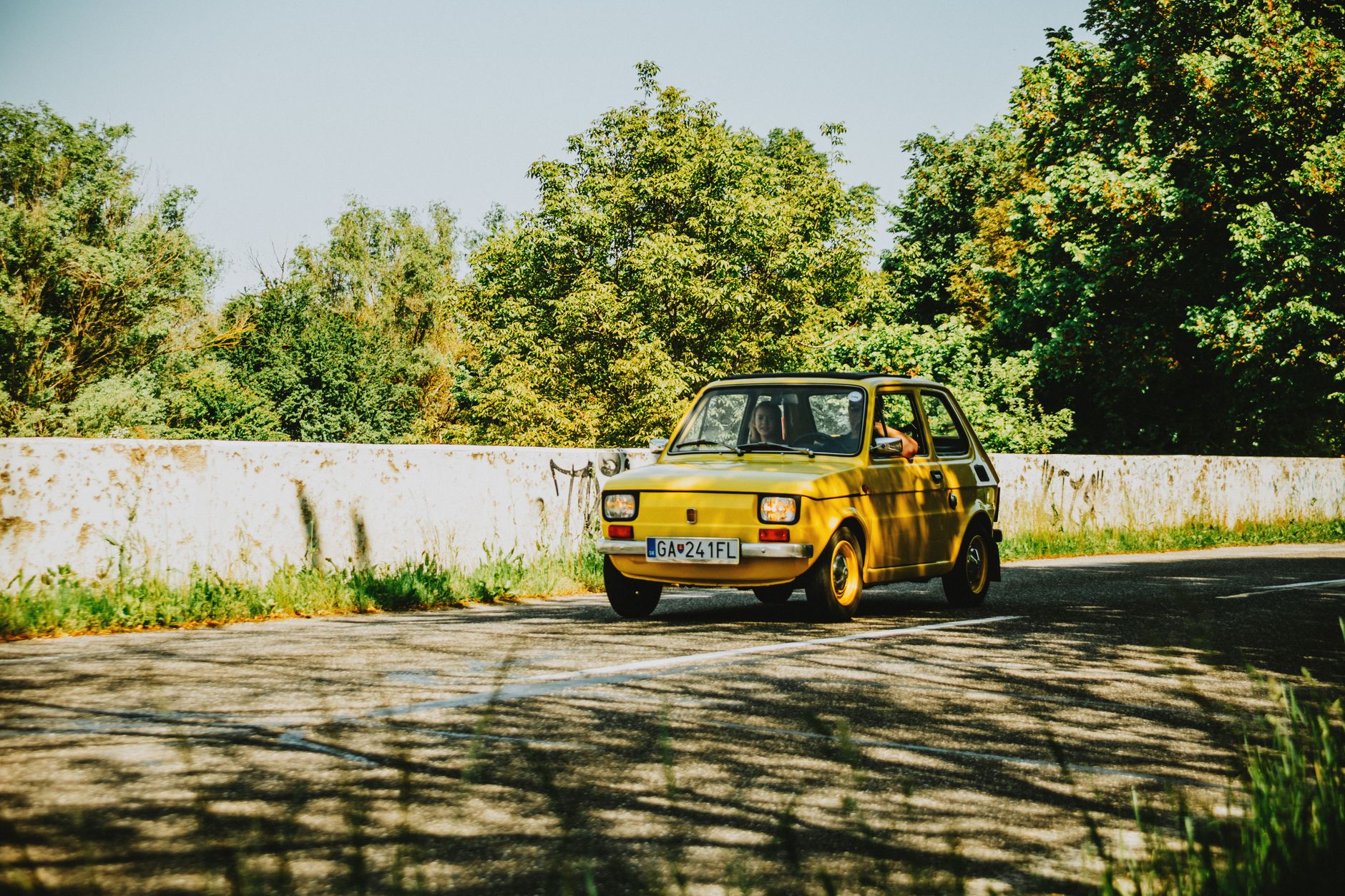 Voiture ancienne jaune sur route de campagne