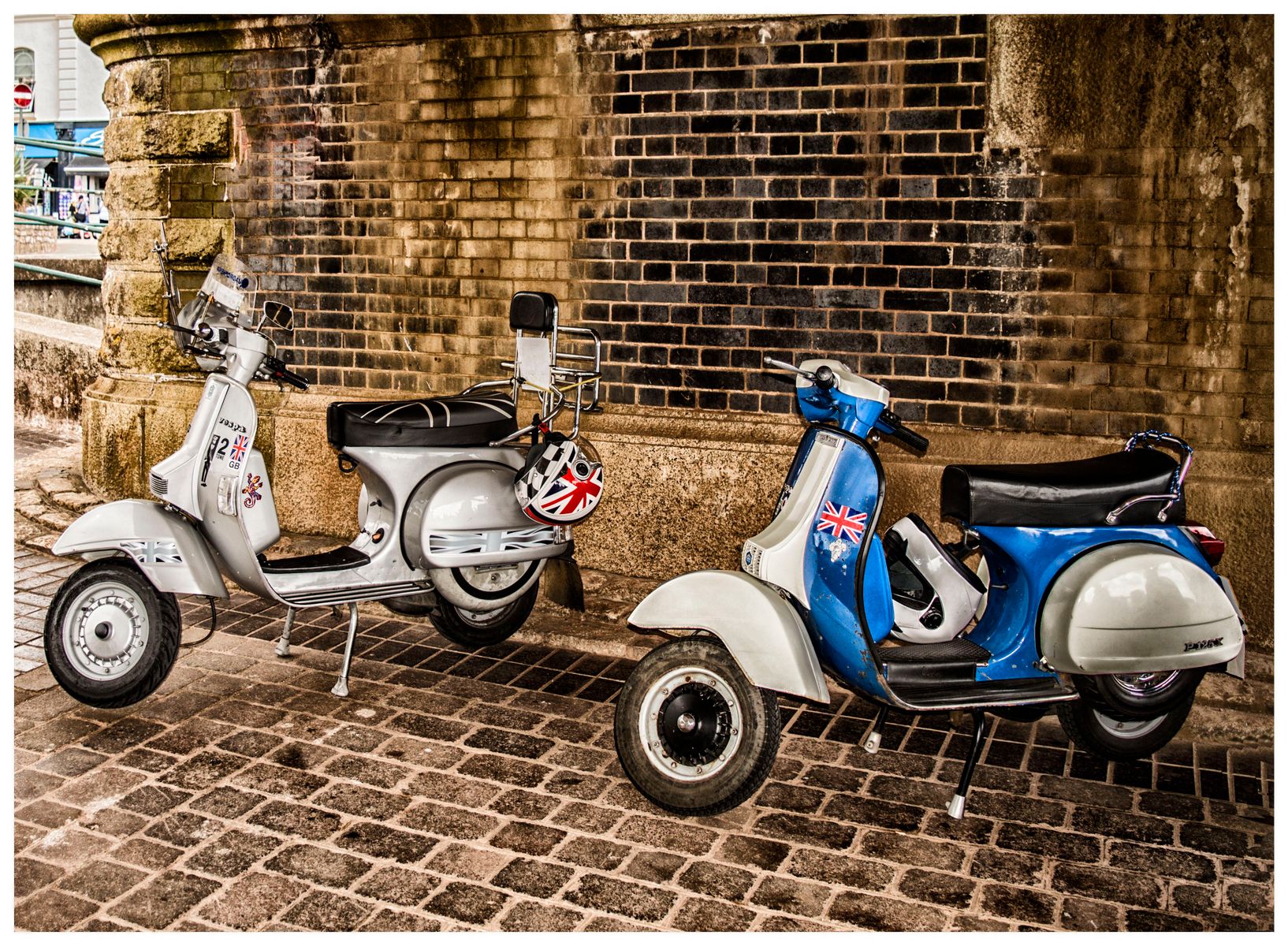 Scooters vintage garés sous une arche en brique