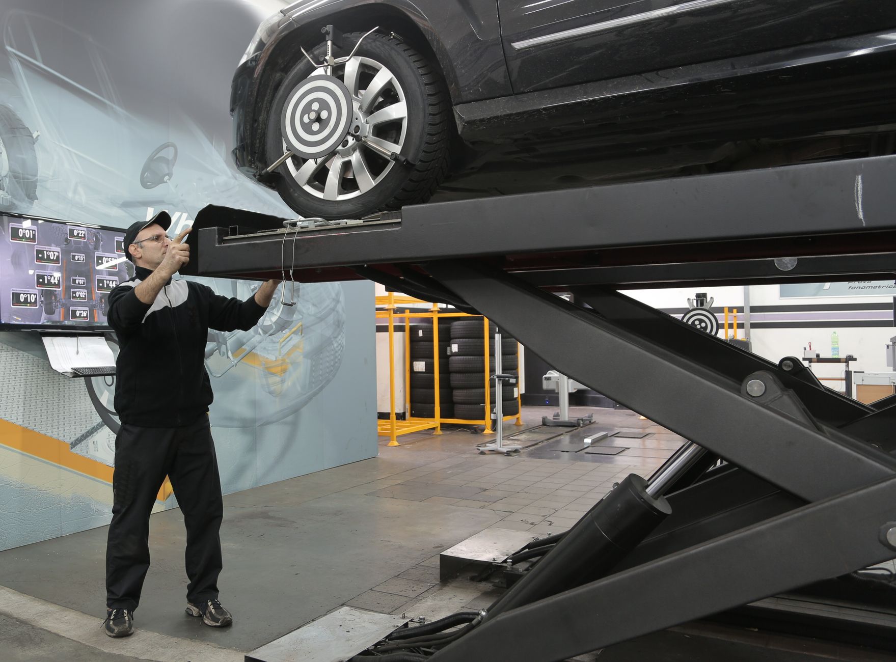 Mécanicien examinant des roues de voiture