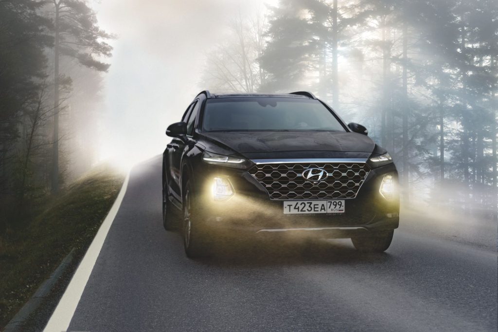 SUV noir sur route forestière brumeuse