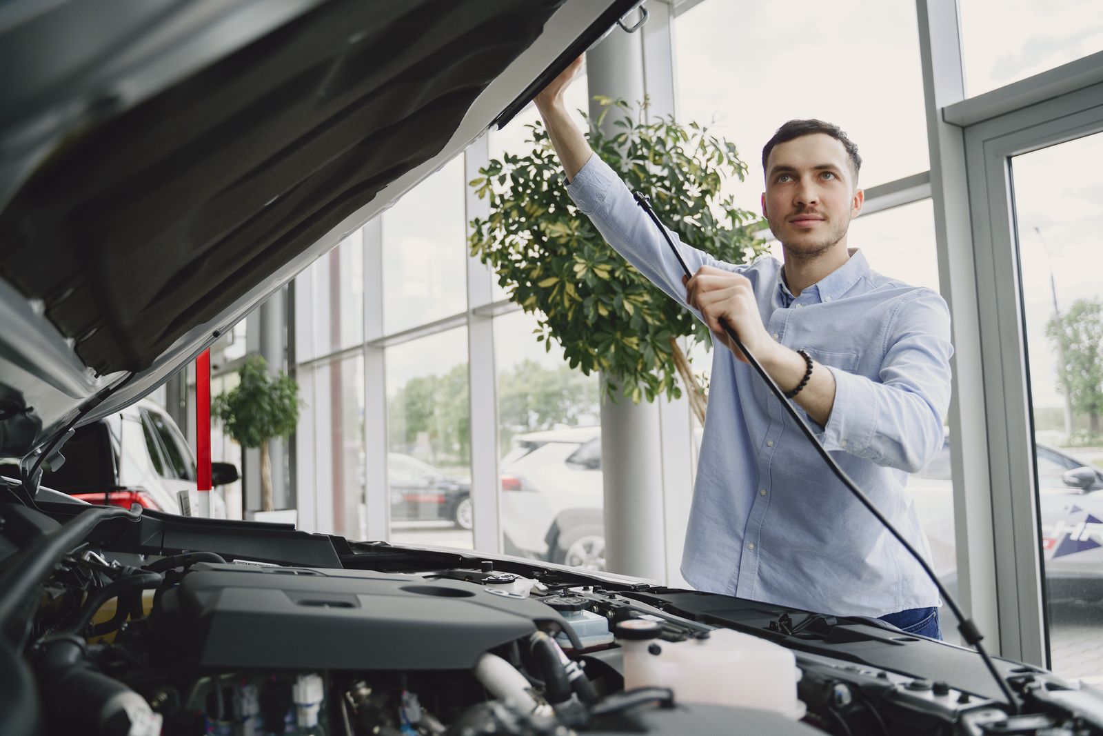 Homme qui inspecte le moteur d'une voiture avant l'achat