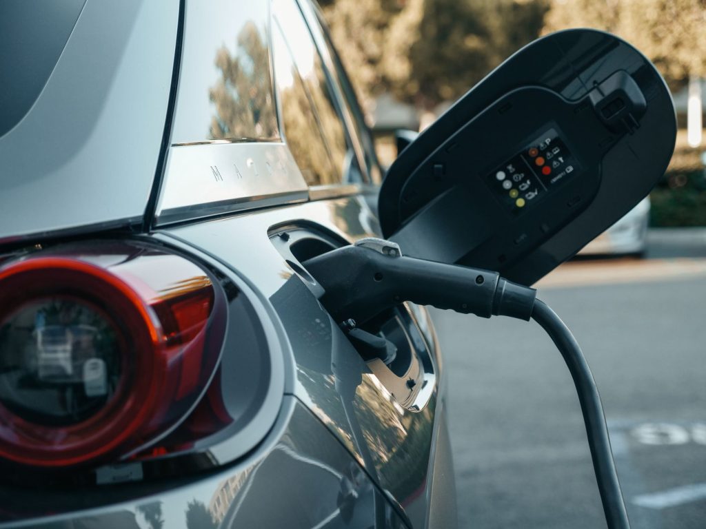 Voiture hybride branchee a une borne de recharge