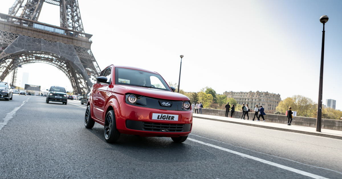 Voiture sans permis Ligier rouge roulant à Paris devant la tour Eiffel