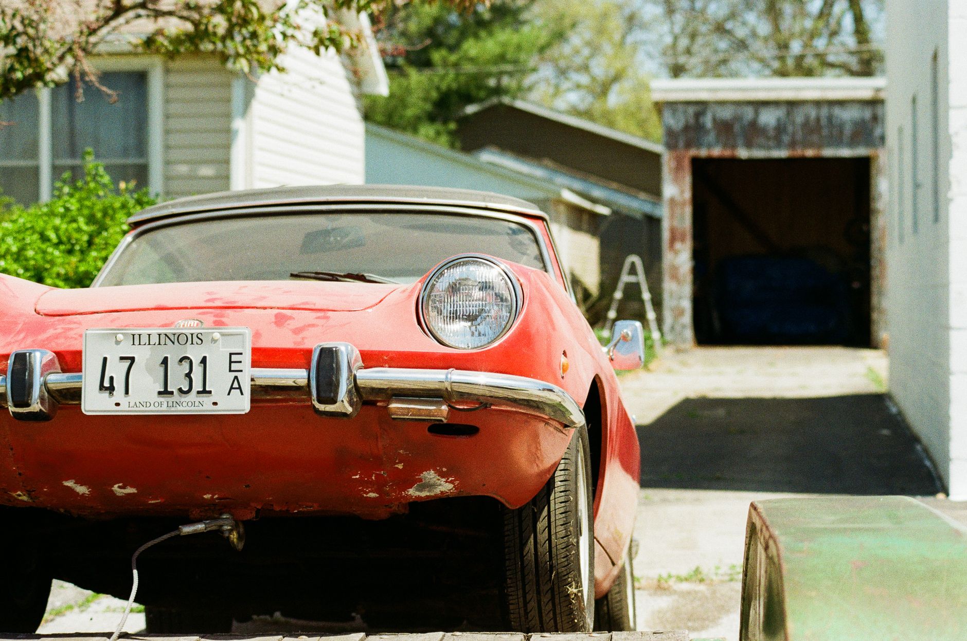 Voiture ancienne rouge garée avec sa plaque
