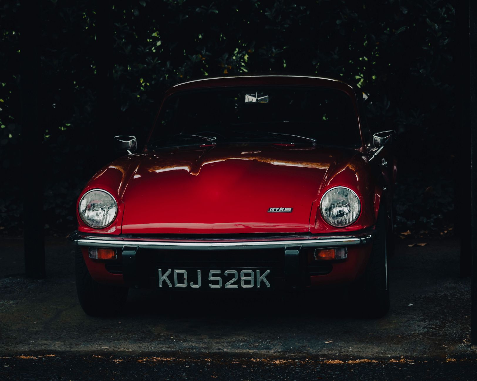 Voiture de sport rouge d’époque garée dehors